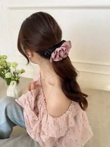 Détail d'une pince à cheveux élégante en satin rose avec nœud pour une queue de cheval chic