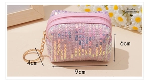Monedero rosa con lentejuelas y llavero dorado, tamaño 9x6cm en una escena acogedora