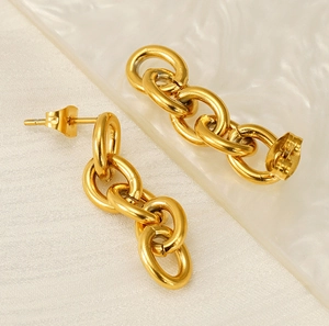 Macro detail of gold link earrings with polished finish and butterfly backs