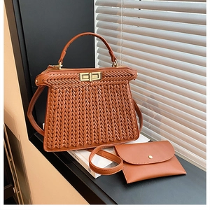 Close-up of woven brown handbag with golden square twist lock and matching small card pouch