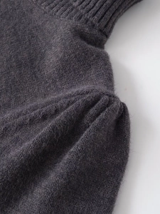 Détail de maille gris foncé montrant la texture douce du cachemire et le pli à l'épaule
