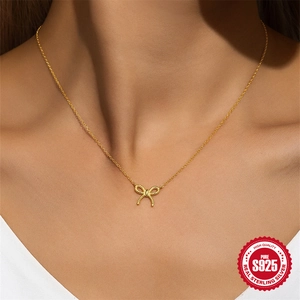 Collier élégant avec pendentif nœud en argent sterling S925 doré porté par un modèle