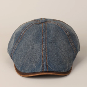Detailed view of navy denim ivy cap with contrast orange stitching and brown leather brim