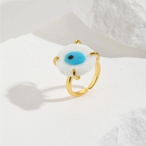 Adjustable golden evil eye ring with blue glass charm on elegant white stone base