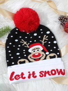 Close-up of Let It Snow knit hat with reindeer pattern on a festive background