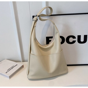 Detail of a beige PU leather shoulder bag with an outer pocket and adjustable strap