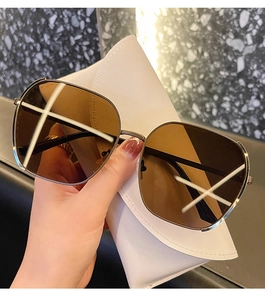 Close-up of stylish oversized square sunglasses with gold frames and brown lenses