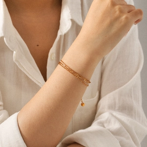 Three-layer 18k gold plated stainless steel bracelet with delicate coin pendants on wrist