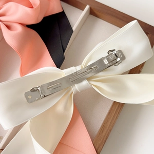 Detailed back view of the satin bow hair clip showing the durable metal spring fastener