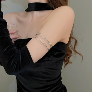Detail view of a minimalist silver multi-layer spiral upper arm cuff on a female model
