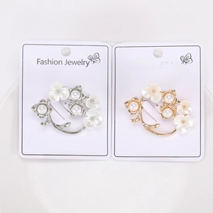 Close-up of elegant gold and silver floral brooches with pearls on jewelry cards