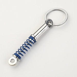 Detail of silver shock absorber keychain with vibrant blue spring and metallic ring