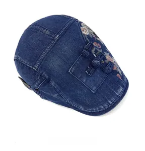 Vue de dessus d'une casquette plate en jean bleu avec broderie florale et boutons