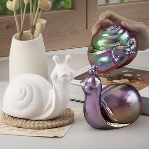 Artistic snail figurines in white and iridescent finishes displayed as home decor