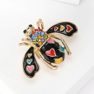 Detailed close-up of a colorful bee brooch with enamel wings and rhinestone accents