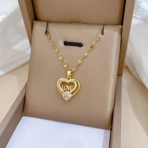 Makro-Detail der goldenen Herz-Halskette mit LOVE-Gravur in einer Geschenkbox