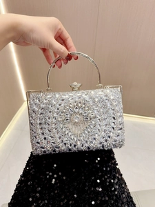 Close-up of sparkling floral rhinestone patterns and metal ring handle on evening clutch bag