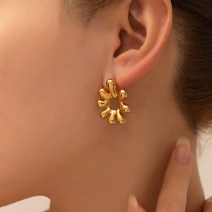 Elegant gold titanium steel heart earrings with abstract floral design on female model