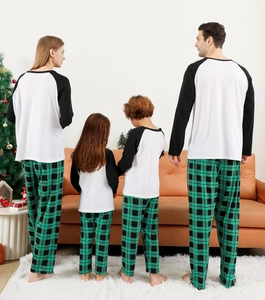 Family matching pajama set with green plaid pants and raglan shirts in a cozy home setting