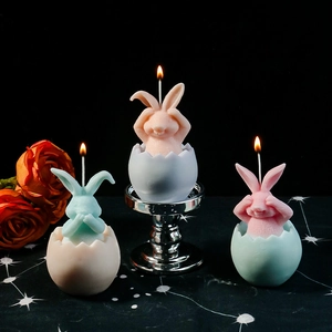 Tre candele accese a forma di coniglio nell'uovo, decorazione tavola creativa rosa e blu
