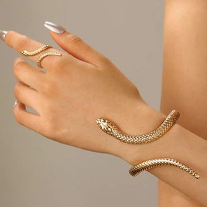 Exaggerated gold snake bracelet and ring set with realistic scale texture on a model