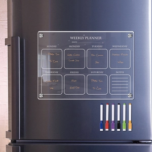 Close-up of magnetic acrylic weekly planner with six colorful dry erase markers on a fridge