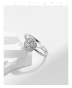 Macro detail of silver square halo ring with sparkling stones on geometric pedestal