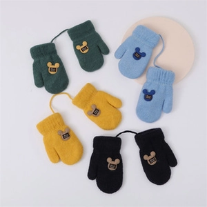 Detail of four pairs of warm knit baby mittens with strings and cute bear patches
