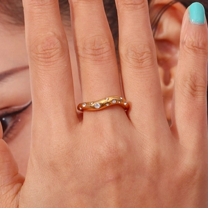 Close-up of 18K gold plated wave ring with micro-pave crystals on a model's finger