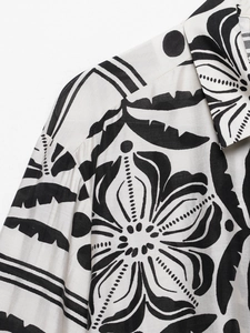 Détail du col de chemise blanc avec imprimé floral noir et coutures d'épaule précises