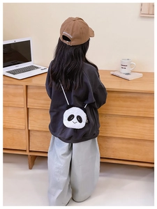 Toddler wearing a plush panda crossbody bag with black hoodie and casual pants