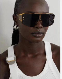 Close-up of steampunk oversized shield sunglasses with gold metal frame details on model
