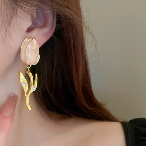 Gros plan de boucles d'oreilles tulipes roses avec perles et strass sur un mannequin