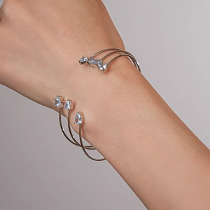 Détail d'un bracelet manchette argenté avec oxydes de zirconium bleus en forme d'étoile