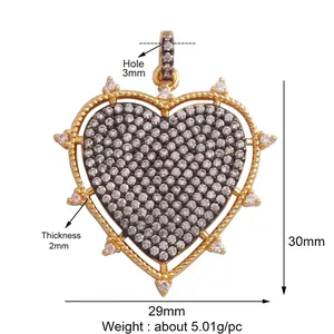 Macro shot of heart-shaped zircon pendant with black and white pavé setting and gold base