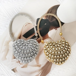 Close-up of gold and silver heart-shaped mini evening bags with sparkling rhinestones