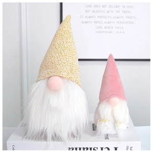 Close-up of pink and gold Nordic gnome ornaments with knitted hats and white faux fur beards