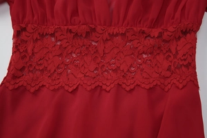 Gros plan sur les détails de dentelle et la taille ajustée d'une robe courte rouge