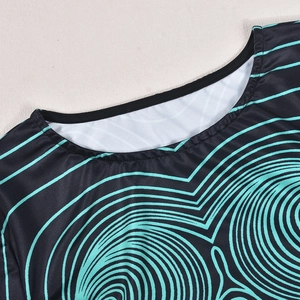 Détail du col rond sur un haut court noir avec motif ondulé numérique cyan