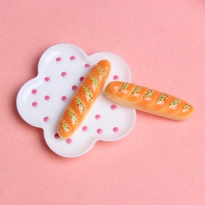 Vue macro de deux baguettes miniatures réalistes sur une assiette à pois pour maison de poupée