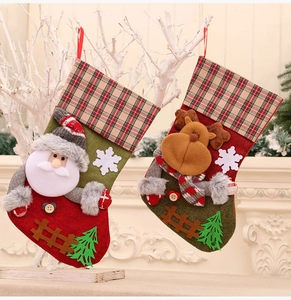 Detail von Weihnachtssocken mit 3D-Weihnachtsmann und Rentier auf kariertem Bund