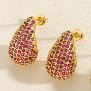 Macro shot of teardrop earrings with pave-set rose red cubic zirconia and gold plating