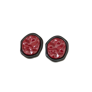 Minimalist geometric earrings featuring textured red resin in a black irregular frame