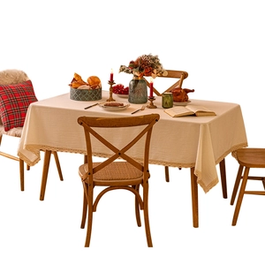 Beige cotton linen tablecloth with lace edges set on a cozy dining table scene