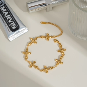 Detailed macro view of 18K gold-plated stainless steel cross charms with lobster clasp