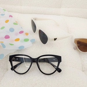 Cat eye children's sunglasses in jelly colors on white textured fabric background