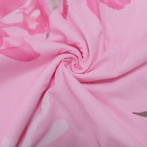 Détail du tissu en maille à imprimé floral rose avec texture volantée et tissage fin
