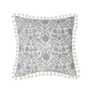 Detail of blue and beige botanical pillow cover featuring decorative tassel fringe edges