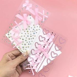 Detail of adhesive pink ribbon bows and iridescent rhinestone facial makeup stickers
