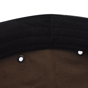 Détail macro de l'intérieur d'une casquette en coton avec œillets et coutures renforcées